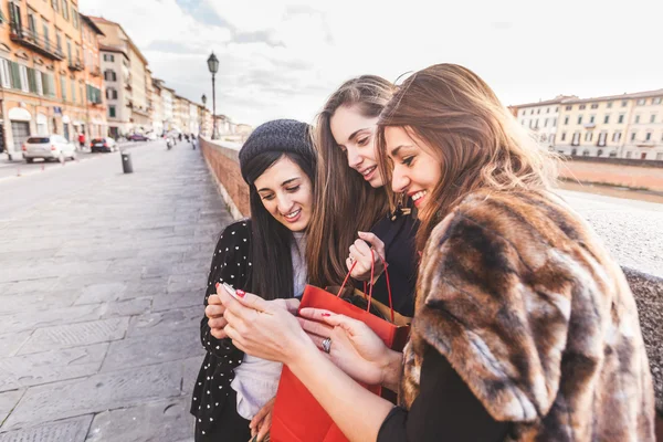 Mulheres com telefone inteligente e sacos de compras — Fotografia de Stock