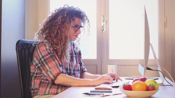 Молода жінка працює вдома або в маленькому офісі — стокове відео