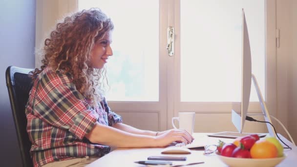 Jeune femme travaillant à la maison ou dans un petit bureau — Video