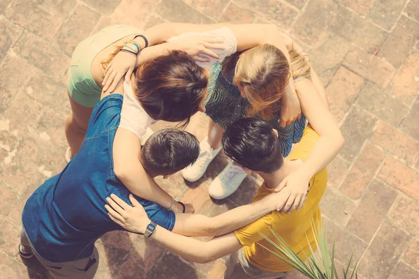 Группа подростков обнимается по кругу, вид с воздуха — стоковое фото