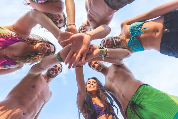 Группа друзей со стопкой рук на берегу моря — стоковое фото