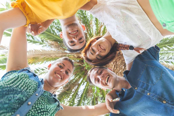 Group of teenagers embraced in circle, bottom view — Stock Photo, Image