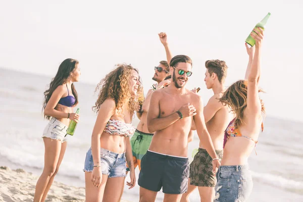 Multiraciale groep vrienden met een feestje op het strand — Stockfoto