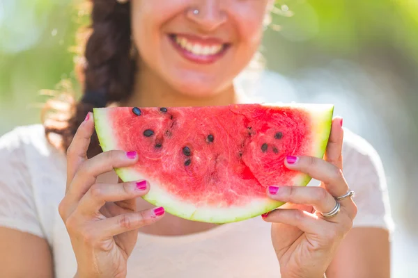 Schöne junge Frau im Park isst eine Scheibe Wassermelone — Stockfoto