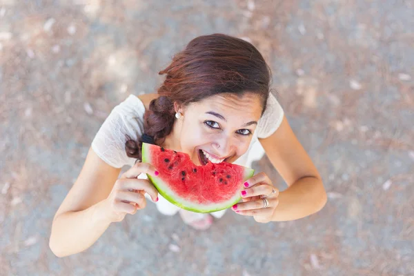 Mulher bonita no parque comendo uma fatia de melancia — Fotografia de Stock