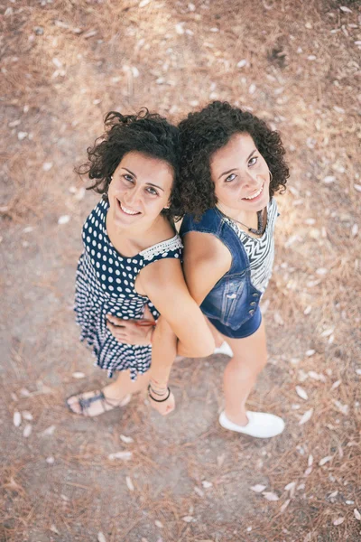 Duas belas jovens mulheres abraçadas e olhando para cima — Fotografia de Stock