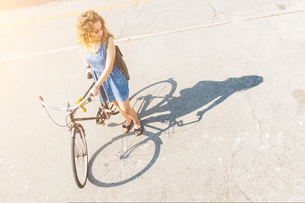 Mujer con bicicleta con su sombra en el camino . — Foto de Stock