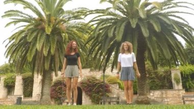 Parkta zıplayan iki kızın yavaş çekim görünümü