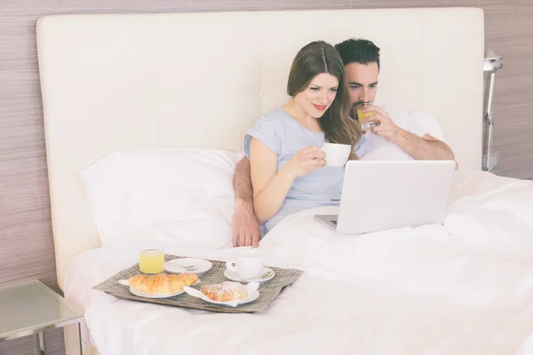 Couple having breakfast on the bed — Stock Photo, Image