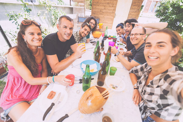 Group of people taking selfie while having lunch outdoor