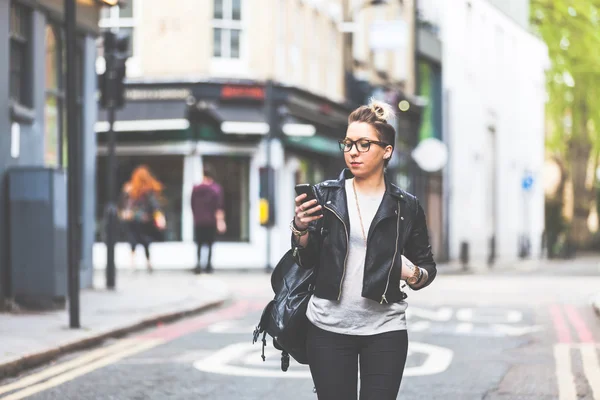 Mädchen läuft mit ihrem Handy die Straße hinunter. — Stockfoto