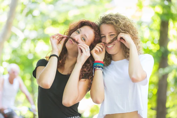 Dos chicas haciendo bigote con su pelo . —  Fotos de Stock