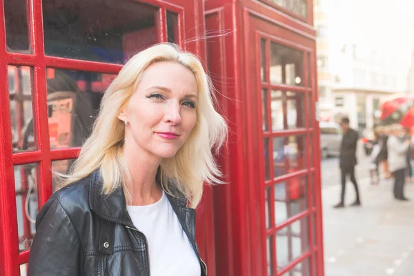Beautiful woman portrait in London with red phone booth — Stock Photo, Image