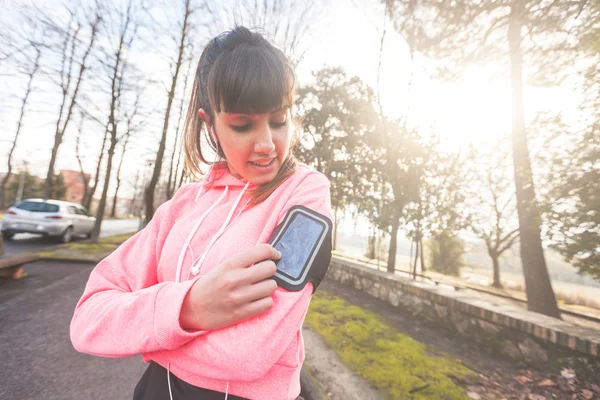 Egzersiz sırasında akıllı telefon kontrol sportif genç kadın — Stok fotoğraf