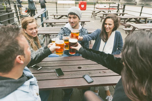 Grupo de amigos desfrutando de uma cerveja no pub em Londres — Fotografia de Stock