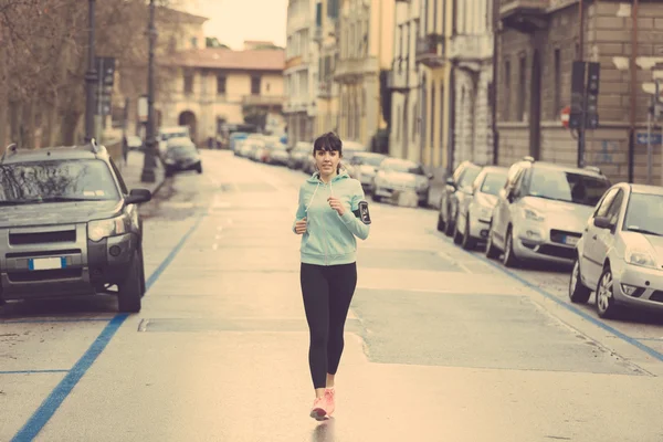 Hermosa joven corriendo sola en la ciudad — Foto de Stock