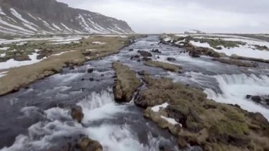 Winter landscape in Iceland with river and waterfall through the countryside in a typical Icelandic view. Travel and wild nature concepts