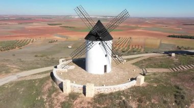 Aerial view of windmills in the countryside in Spain - White windmills in Castilla La Mancha region on a sunny day - Travel destinations and industrial architecture in southern Europe