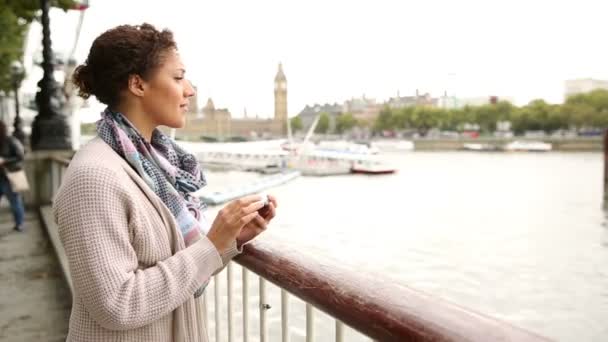 Young woman looking for informations on smart phone in London — Stok video