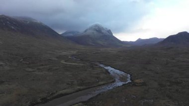 İskoçya 'daki Skye Adası' nın gündoğumunda, dağların üzerinde bulutlar ve vadideki su akıntısı - İskoç dağlarında karamsar hava, seyahat ve doğa kavramları