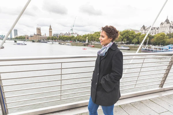 Молодая женщина смешанной расы ходит по мосту в Лондоне — стоковое фото