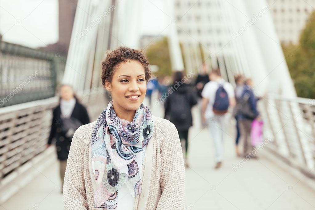 Young mixed race woman walking on a bridge in London