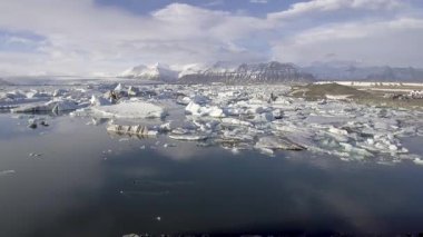 Buzdağı yüzen Jokulsarlon buzulu gölünün ve arka planda dağların havadan görünüşü Vatnajokull bölgesi, doğa ve seyahat kavramlarının insansız hava aracı görüntüsü.