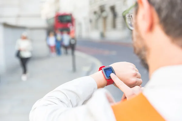 Male commuter in London looking at his smart watch — Stock Photo, Image