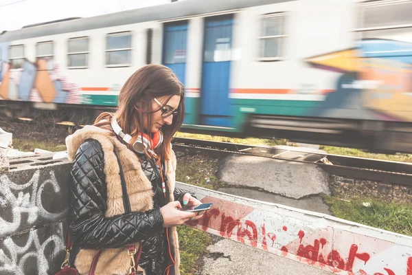 Girl Typing on Smart Phone with Train Passing on Background — Stock Photo, Image