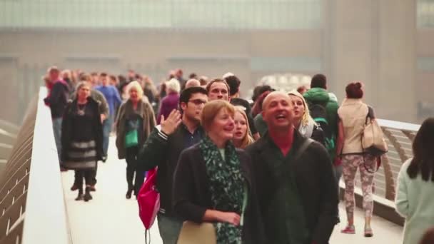 Menigte lopen op Millennium bridge in Londen — Stockvideo