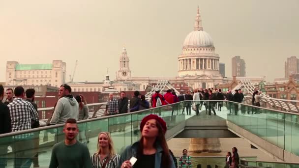 Blick auf die St. Paul Kathedrale in London mit Menschen, die auf der Millennium Bridge gehen — Stockvideo