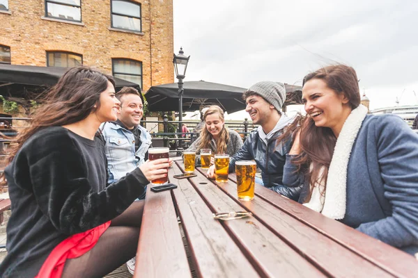 Grupo de amigos desfrutando de uma cerveja no pub em Londres — Fotografia de Stock