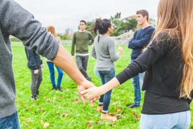 Çok ırklı bir grup arkadaşıyla birlikte bir daire içinde elele