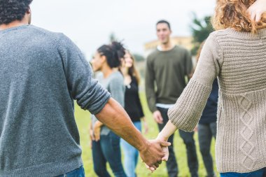 Çok ırklı bir grup arkadaşıyla birlikte bir daire içinde elele