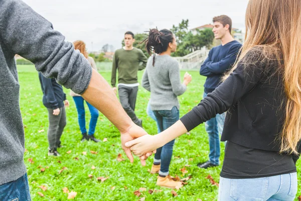 Gruppo multietnico di amici che tengono le mani in cerchio — Foto Stock