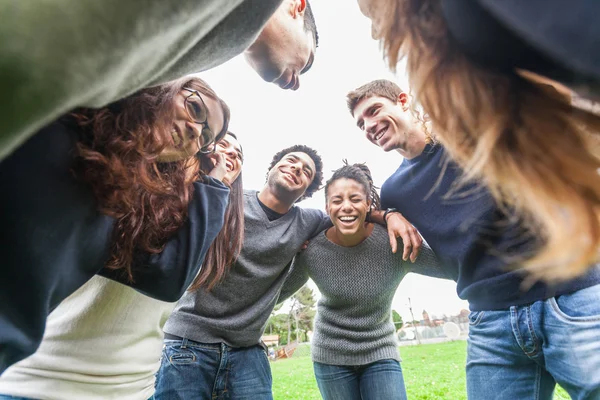 Grupo multirracial de amigos abrazados en un círculo —  Fotos de Stock