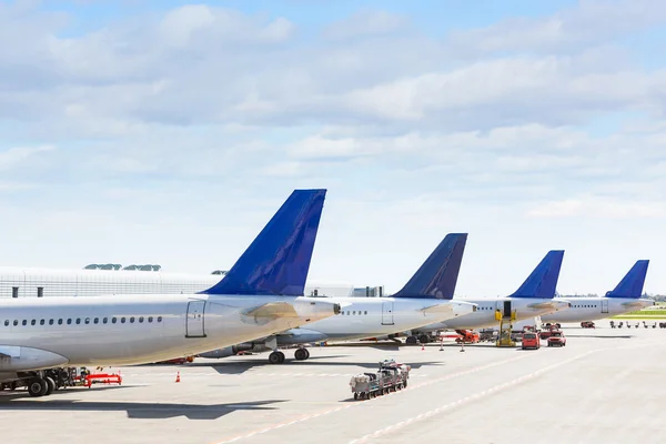 Tails of some airplanes at airport during boarding operation — Stock Photo, Image