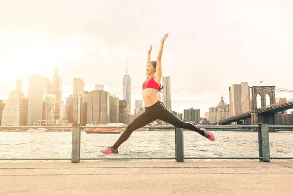 Asian young woman jumping with New York skyline on background — ストック写真