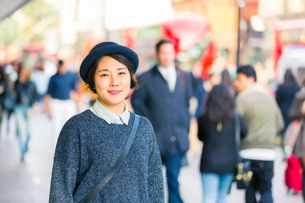 Porträt einer asiatischen Frau mit verschwommenen Personen im Hintergrund — Stockfoto