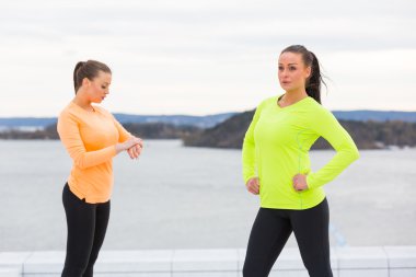 Two women getting ready to start a workout clipart