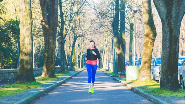 Vacker ung kvinna jogging ensam på park — Stockfoto