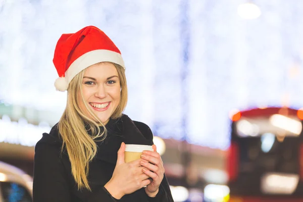 Beautiful young woman wearing Santa hat in London — Stock Photo, Image