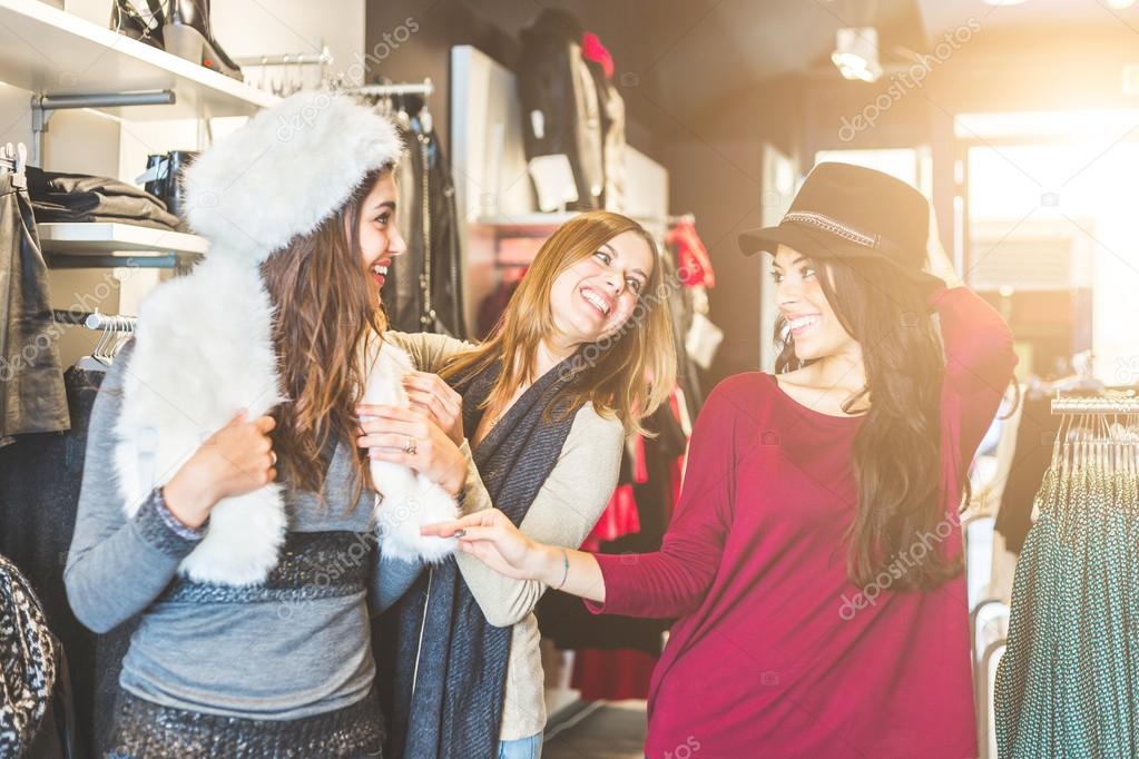 Three women in a clothing store enjoying shopping time