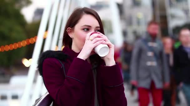 런던에서 다리에 서 있는 차 cuf 들고 아름 다운 젊은 여자 — 비디오