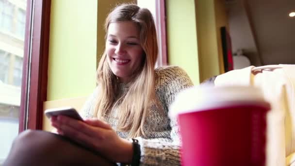 Vrouw in een café van de London kijken naar slimme telefoon — Stockvideo