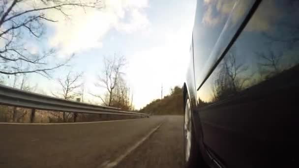 Автомобиль едет по сельской дороге в солнечный день — стоковое видео