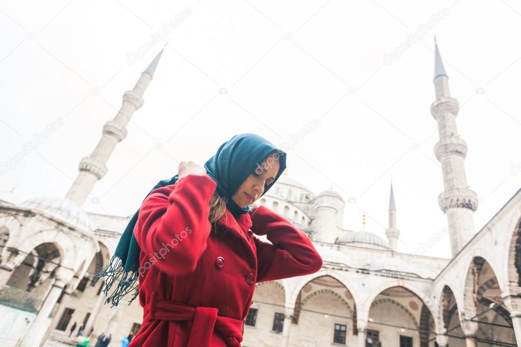 Young Arabian woman wearing veil in front of a mosque in Istanbu