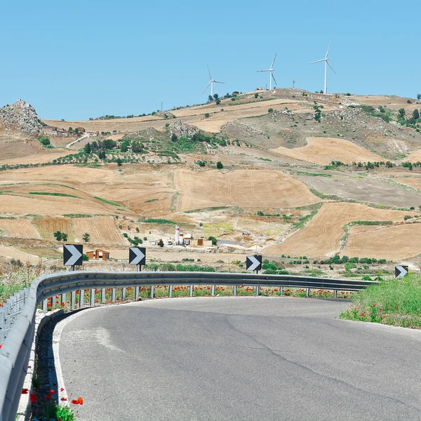 Vägen på bakgrund av de moderna vindkraftverk i Sicilien — Stockfoto