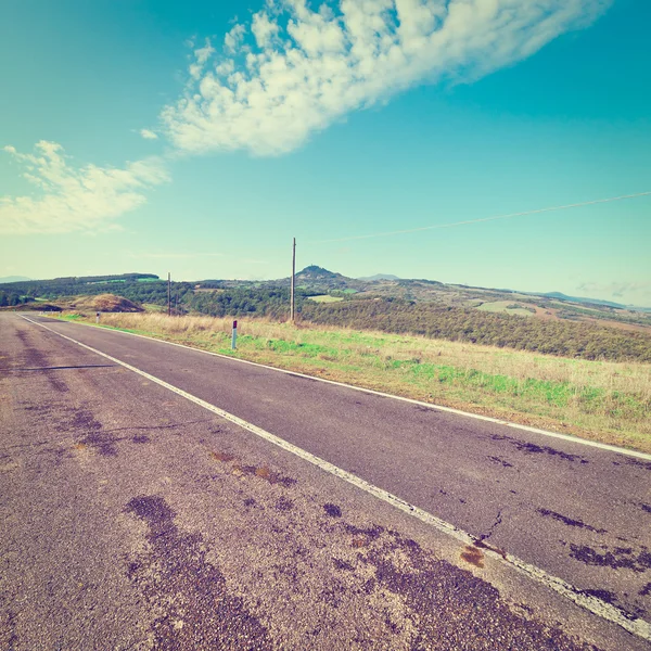 Strada asfaltata tra i campi d'autunno — Foto Stock