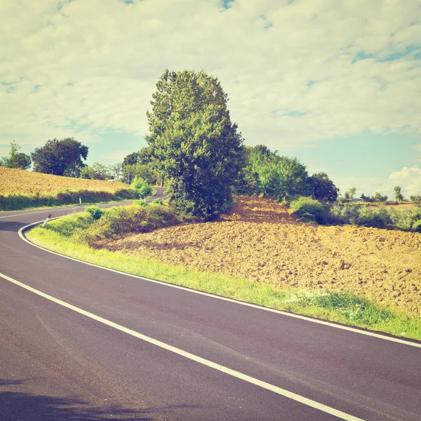 Válcování Dlážděné Silnice Mezi Podzimními Oranými Poli Toskánsku Instagram Effect — Stock fotografie